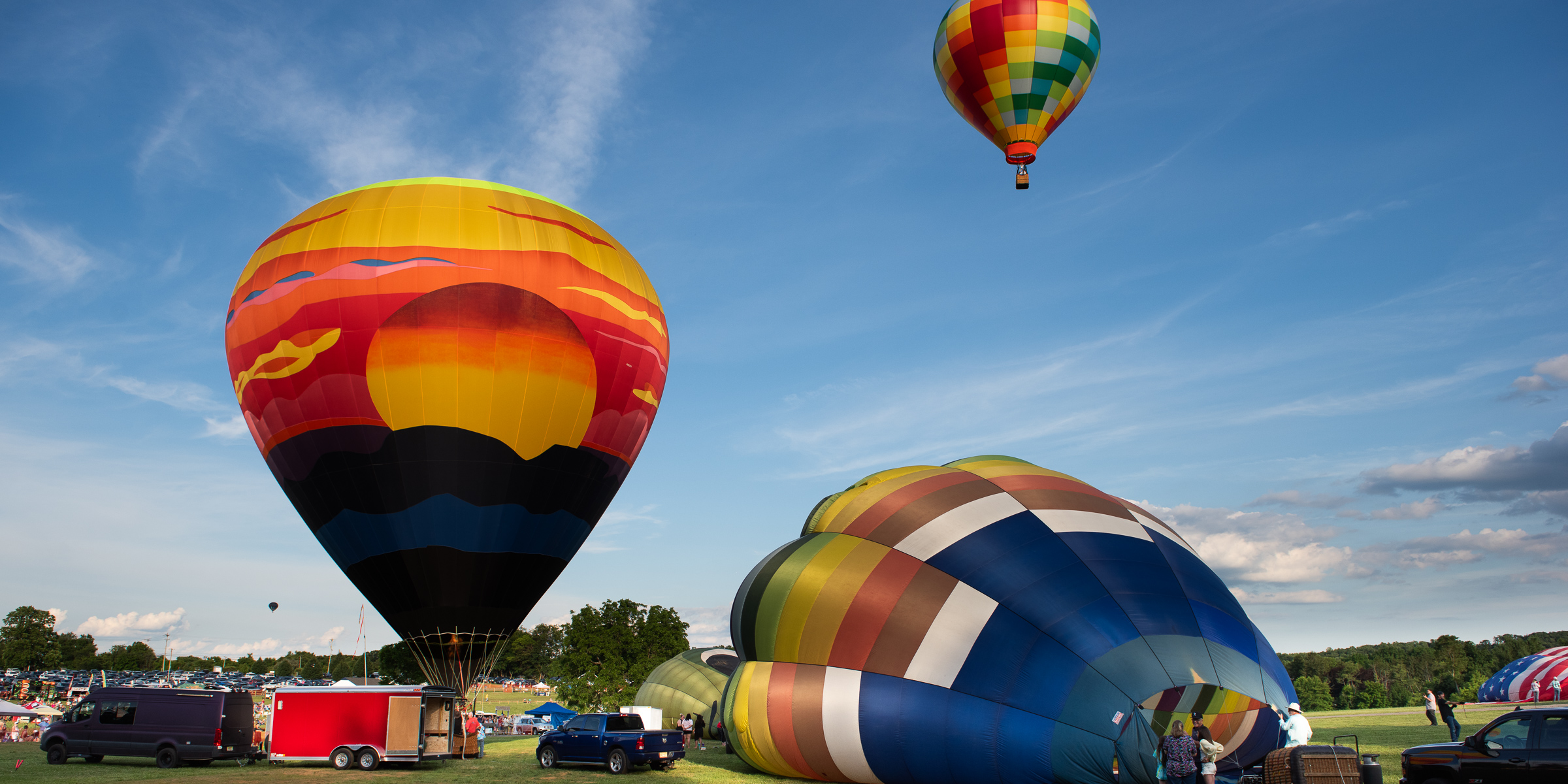 Hot air balloons rising over the festival field at sunrise